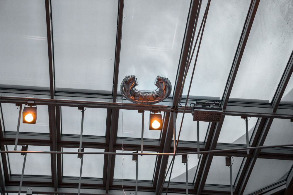 Suspended acoustic baffles and ceiling clouds installed in a large commercial area to enhance sound control and reduce echo.